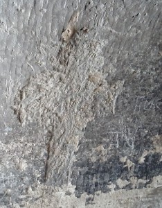 A cross in relief on the wall of the cave.